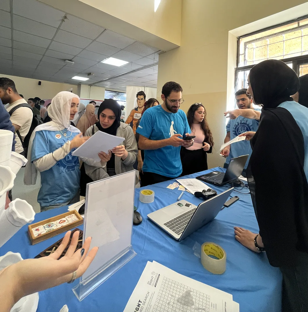 IEEE SIGHT HU members stand behind their project exhibition table at IEEE Day 2025.